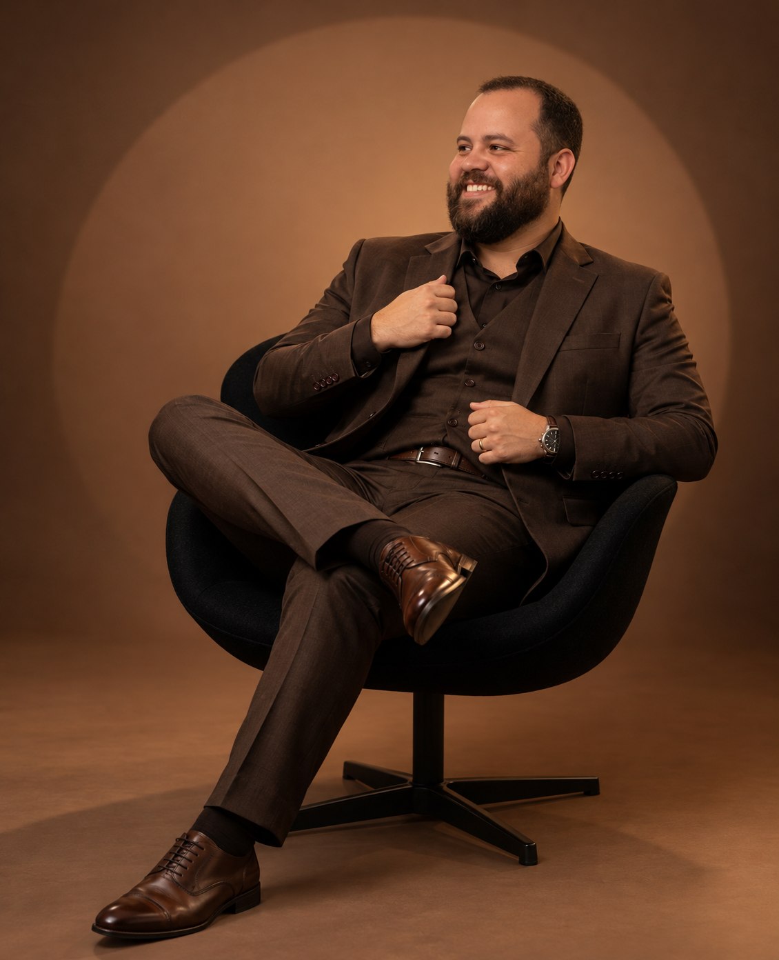 Jones Rodrigues sentado para un retrato de estudio con traje marrón.